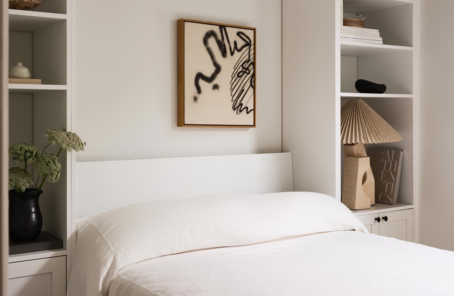 Wall bed in a custom white finish with custom shelving designed by California Closets