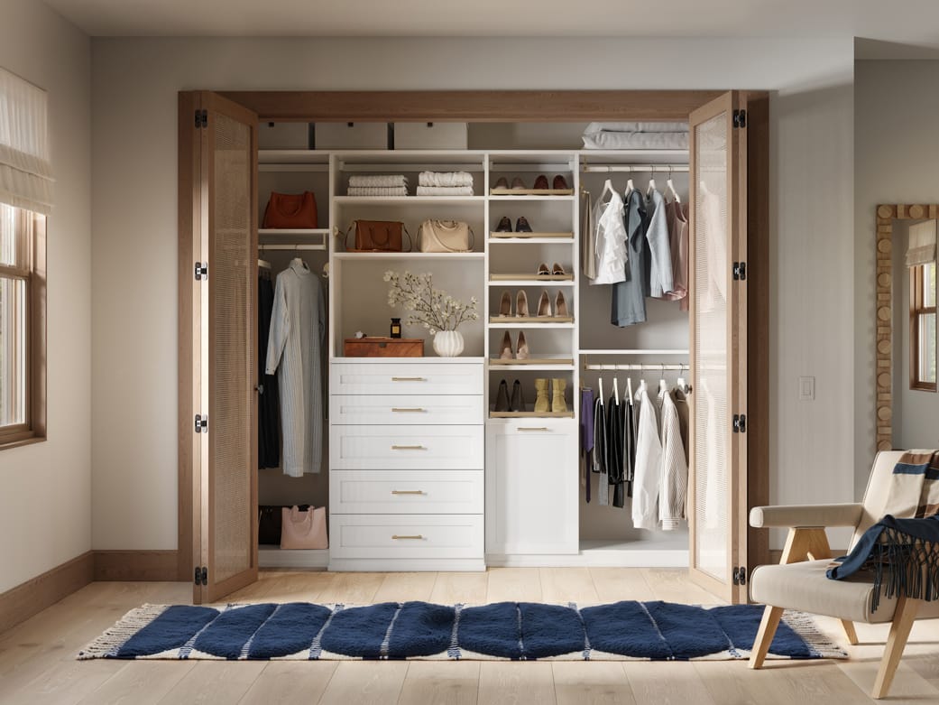 Closet with laundry hamper, drawers, and baskets by California Closets