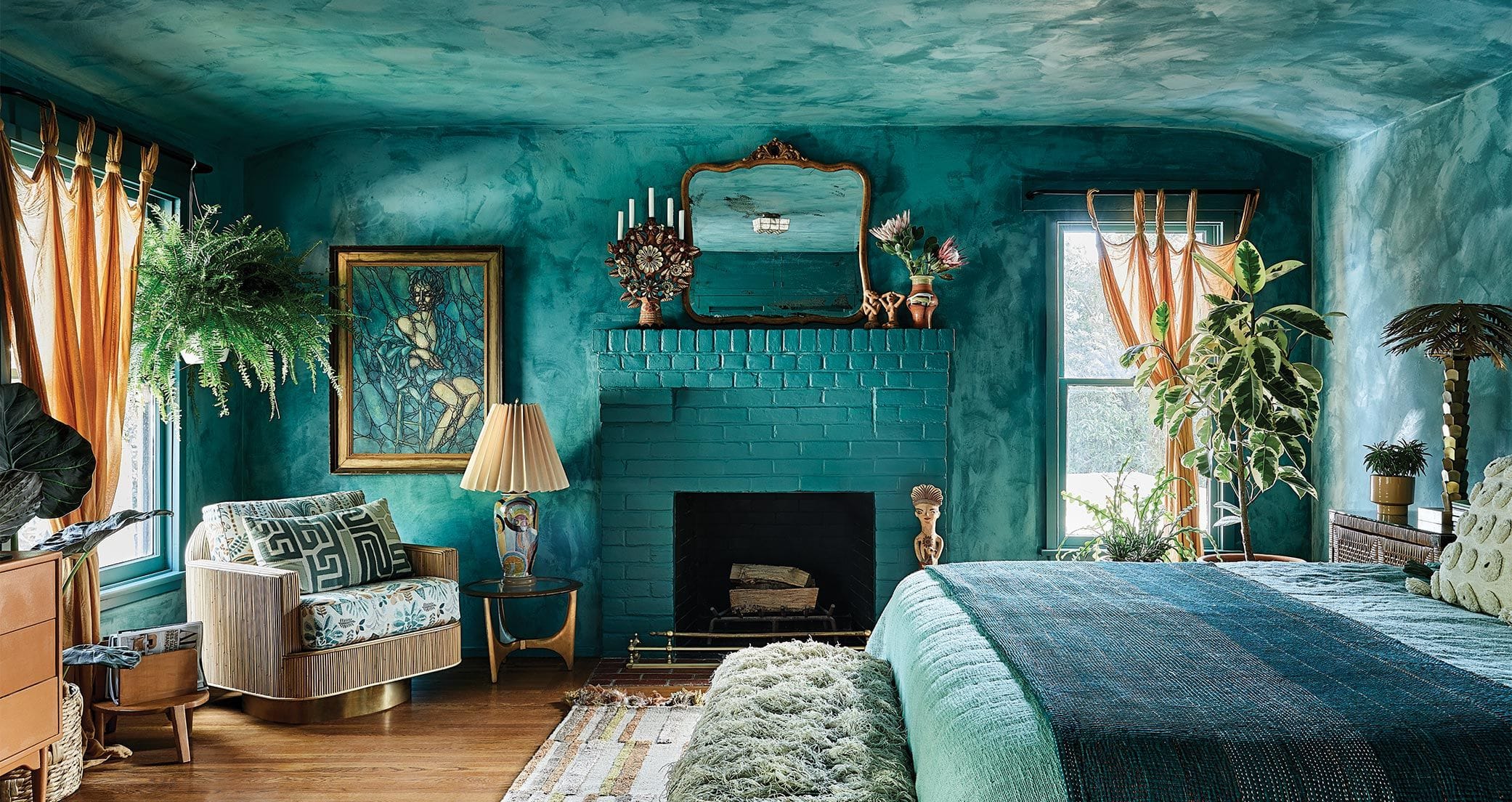 Moody blue washes and leafy plants transform the primary bedroom into a cool subterranean retreat in Ideas of Order Magazine