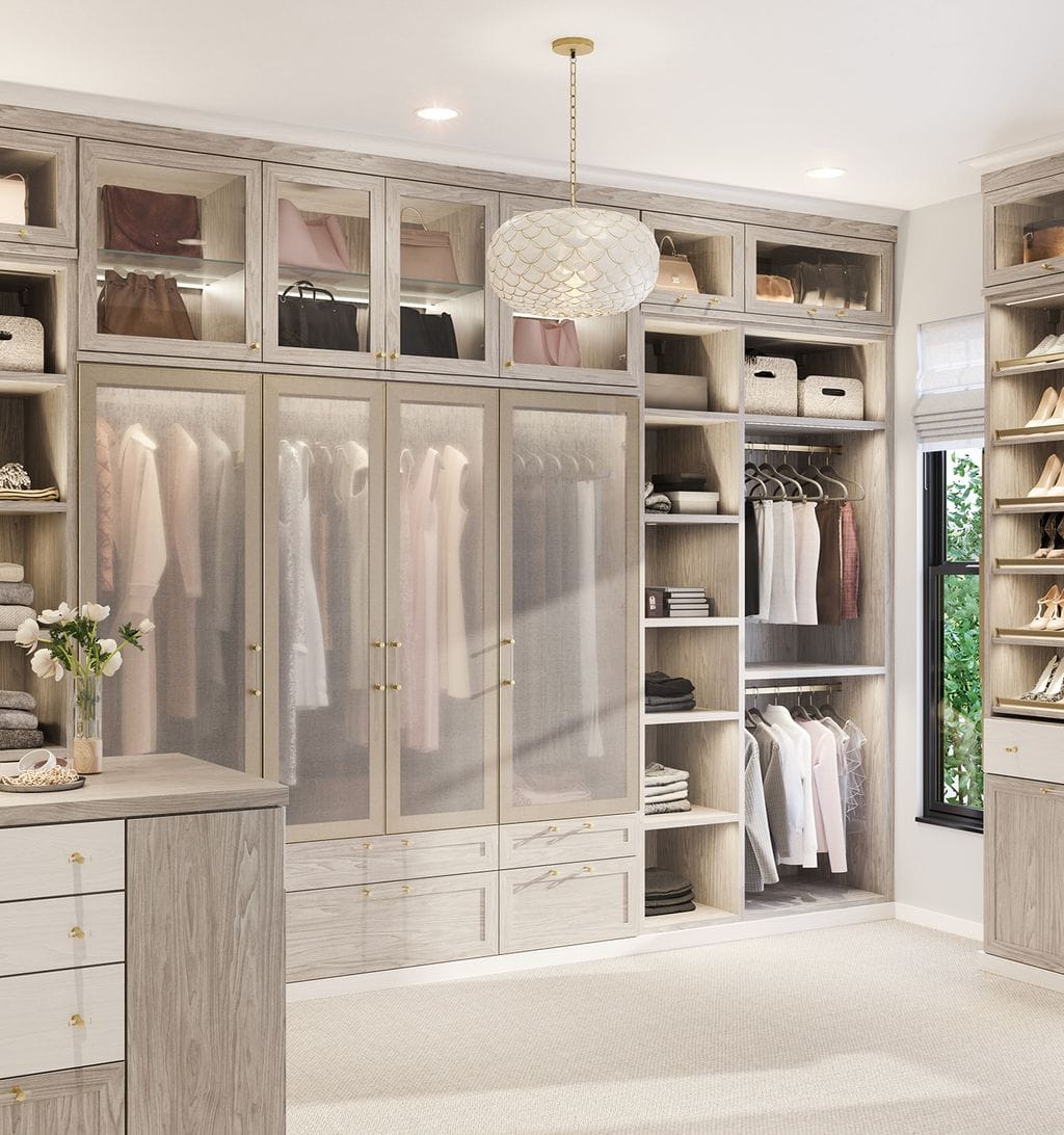L-shaped closet walk in layout center island frosted cabinet doors and shoe storage by California Closets